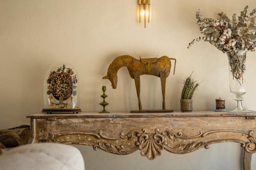 Sculpture et fleurs séchées sur une cheminée de pierre